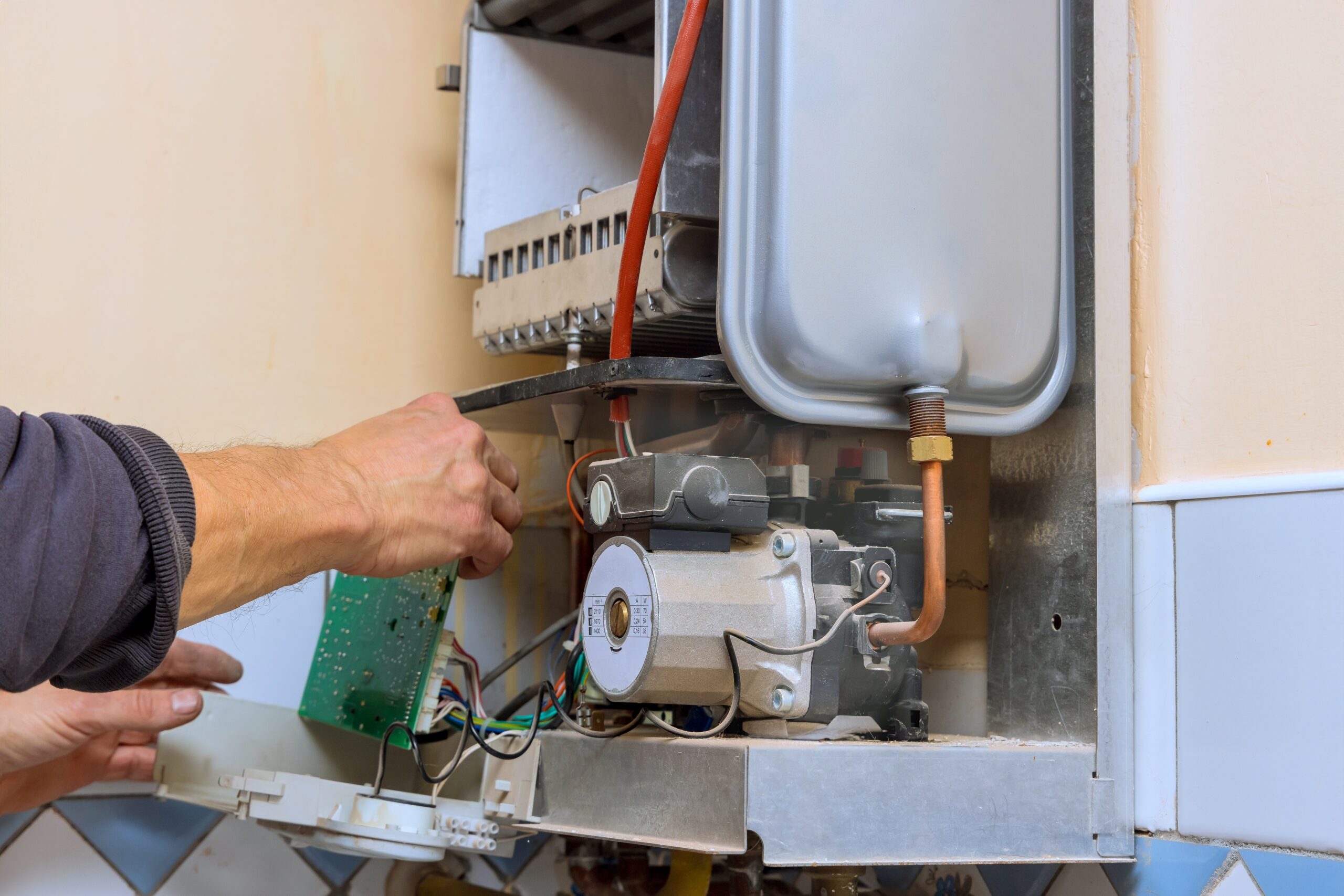 Technician performing water heater repair for temperature fluctuations in a residential system
